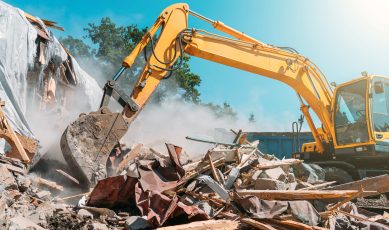 Débris de béton, de gravats, de bois avec une pelleteuse/micro-pelle sur un chantier de construction